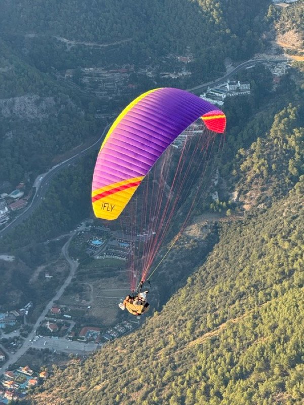 Mor-sarı iFLY kanadı ile dağlar üzerinde uçuş